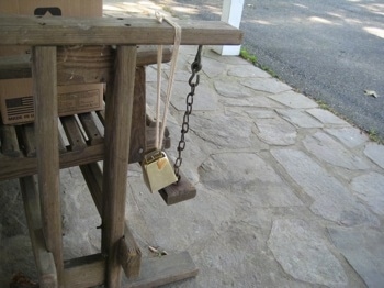 Peanut Butter bell on the arm of a wooden porch glider