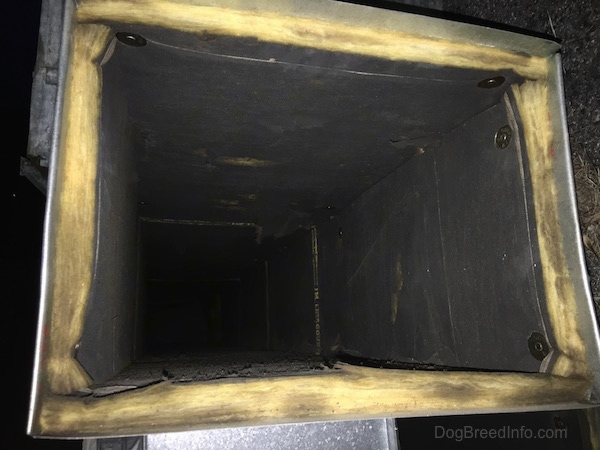 The inside of a fiberglass lined HVAC air duct that is very dirty and dry rotted.