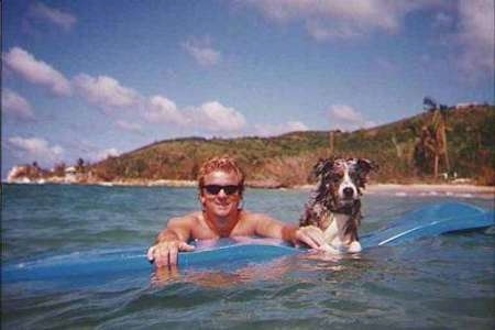 Baron the Australian Shepherd is using a raft to stay a float next to his owner