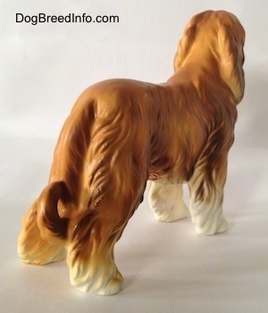 The back right side of a brown with white Vintage porcelain Lefton Japan Afghan Hound dog figurine. The dog's long tail is curled at the tip.