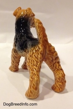 The back left side of a black and brown Vintage Airedale Terrier dog West Germany Goebel figurine. Its back legs are set wide apart.
