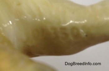 Close up - Engraved Numbers on the inside leg area of a black and tan with white Vintage Goebel Airedale Terrier porcelain dog figurine.