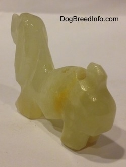 The back left side of a stone Basset Hound figurine.