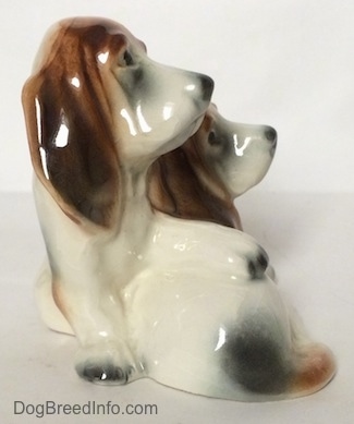 The right side of a ceramic Basset Hound figurine that is two Basset Hounds. The figurine is very glossy.