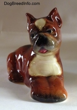A brown with white and black Boxer puppy figurine. The figurine is very glossy.