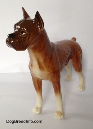 The front left side of a brown Boxer dog figurine. The figurine is very glossy.