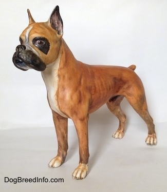 The front left side of a brown with black and white Boxer figurine with a matte finish. The figurine has very detailed eyes.