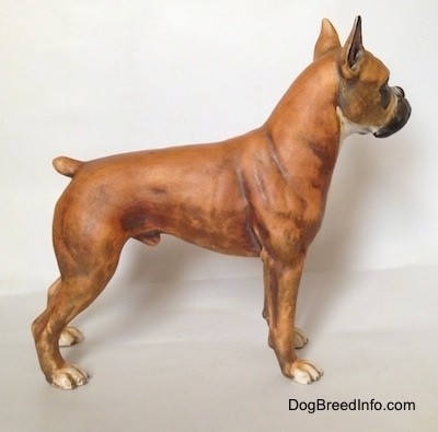 The right side of a brown with black and white Boxer figurine with a matte finish. The figurine has a very detailed body.