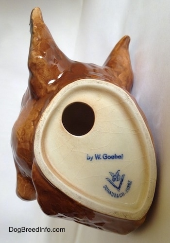 The underside of a fawn Boxer head wall mount. The logo of Goebel W. Germany is on the underside and there is a hole above it.