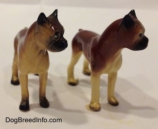 Two different color variations of the miniature Boxer Mama figurine.