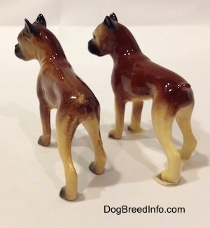 The back left side of two different color variations of the miniature Boxer mama figurine. The figurines both have great paw details.