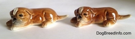 The left side of two brown with white Boxer puppy figurines and they both have detailed faces.