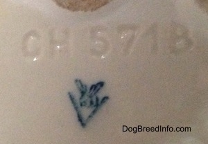 Close up - The underside of a miniature white English Bulldog figurine. On the underside there is a Goebel W.Germany logo and above it is the number/letter combination - CH571B.