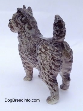 The back left side of a gray and white Cairn Terrier figurine. The figurine has fine hair details.