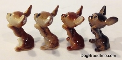 The left side of four different Chihuahua figurines that are in a begging position. The figurines are glossy.
