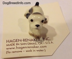 A white with black ceramic Cocker Spaniel puppy figurine.