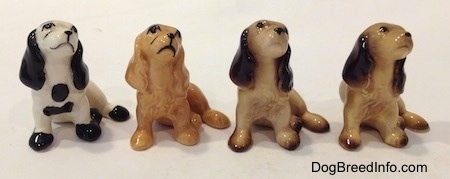 Four color variations of a Cocker Spaniel figurine.