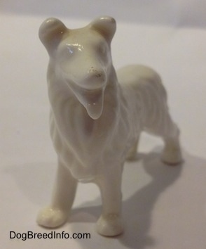 A white bone china Rough Collie figurine. The figurine is glossy.