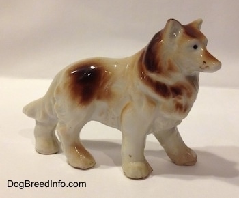 The right side of a brown and white porcelain Rough Collie figurine. The figurine has paw details.