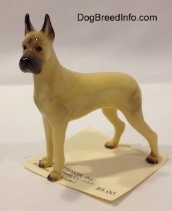The left side of a figurine of a tan with black Great Dane. The figurine has large black tipped ears.
