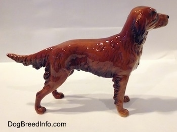 The right side of a brown with black figurine of an Irish Setter. The figurine has hairy ears that are black at the bottom.