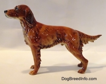 The left side of an Irish Setter figurine. The figurine has its tail out, level wth its body.