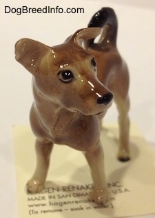 A figurine of a mixed breed dog. The figurine is looking to the right.