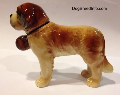 The left side of a figurine of a porcelain Saint Bernard figurine. The figurine has medium length legs.