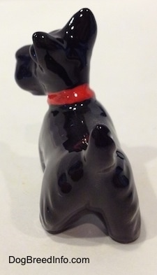 The back left side of a figurine of a Scottish Terrier. The figurine is glossy.
