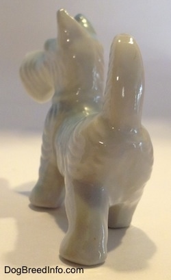 The back of a bone china figurine of a Scottish Terrier. The figurine has its long tail in the air.