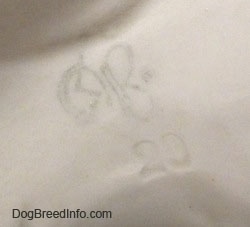 Close up - The underside of a Wire Fox Terrier with the stamp of a Goebel crown mark on it.