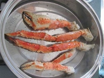 Alaskan King Crab legs are in a pot.