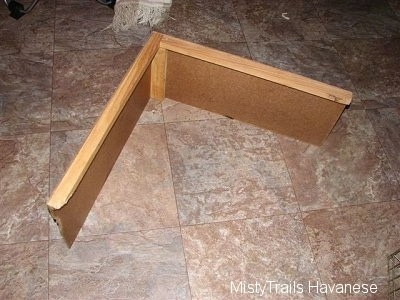 The inside of a wood divider that is used in a whelping box