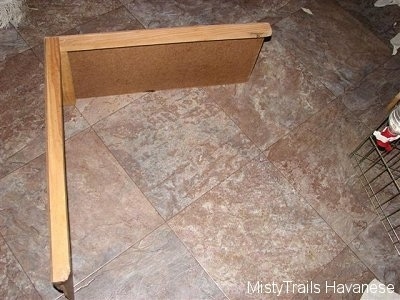 A wood divider that is used in a whelping box.