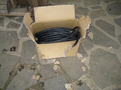 Thick black wire in a cardboard box that is chewed up