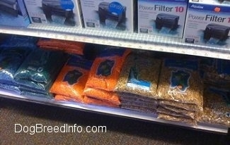 An Assortment of small gravel bags. There is a power filter on a the shelf above