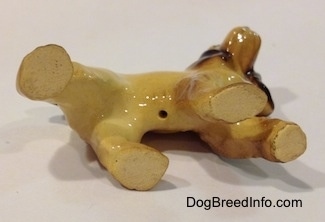 The underside of a tan with black and brown Cocker Spaniel ceramic figurine.