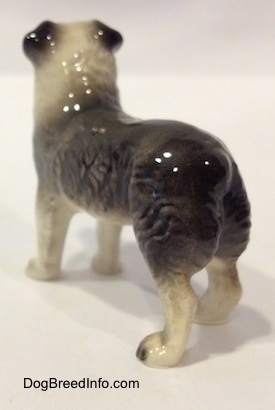 The back left side of a black and white Australian Shepherd figurine. The figurine has hair details on its left side.