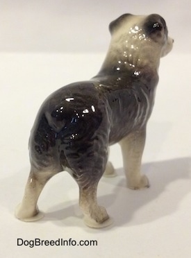 The back right side of a black and white Australian Shepherd figurine. The figurine is painted well.
