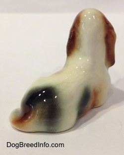 The back of a white with black and red Basset Hound figurine.