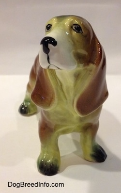 A brown with white and black ceramic Basset Hound figurine.