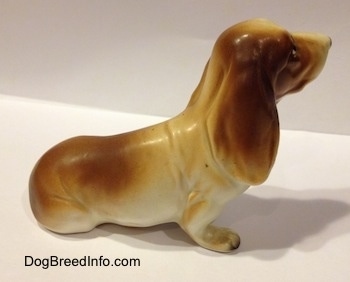 The right side of a brown and white porcelain Basset Hound figurine. The figurine has great ear details.