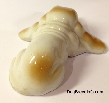 Topdown view of the back of a white with tan porcelain Basset Hound figurine. The figurine has a wrinkly back.