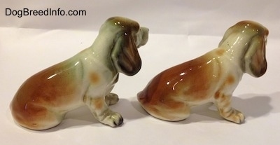 The back right side of two brown and white with black ceramic Basset Hound figurine. The figurine has great paw details.