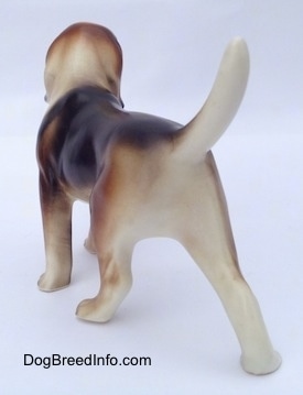 The back left side of a black, brown and white porcelain Beagle Harrier figurine in a standing pose. The figurine has nice paw details.