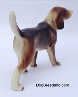 The back right side of a black, brown and white porcelain Beagle Harrier figurine in a standing pose. The legs of the figurine is detailed.