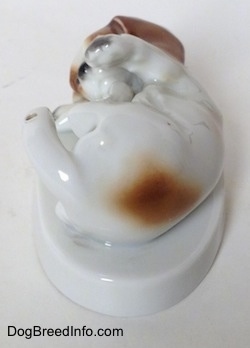 Topdown view of the back side of a white with brown and black Beagle puppy figurine. The figurine is glossy.