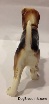 The back side of a black, brown and white ceramic Beagle figurine with a chain ID collar that reads "Beagle".
