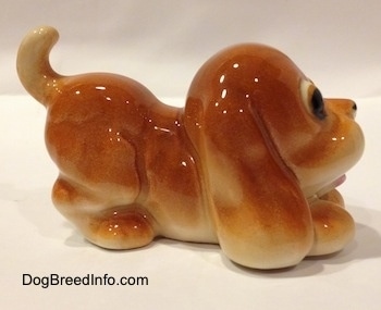 The right side of a tan Cartoon style Bloodhound puppy. The ears of the figurine are easily able to differentiate from the body.