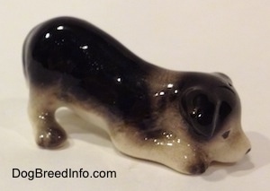The right side of a Hagen-Renaker miniature black with white Border Collie puppy figurine. The figurine has black circles for eyes.